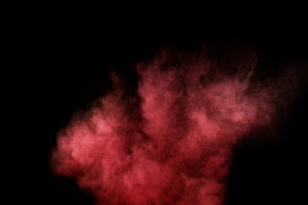 在黑色背景上的红色和粉红色粉末爆炸。彩色的粉末云。多彩的粉尘爆炸。油漆洒红节