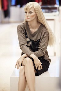 模特坐在商店橱窗陈列女装休闲服装店在购物中心照片