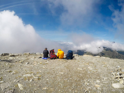 组的朋友站在山顶上的冰川背景下休息。旅游文本的空间的概念