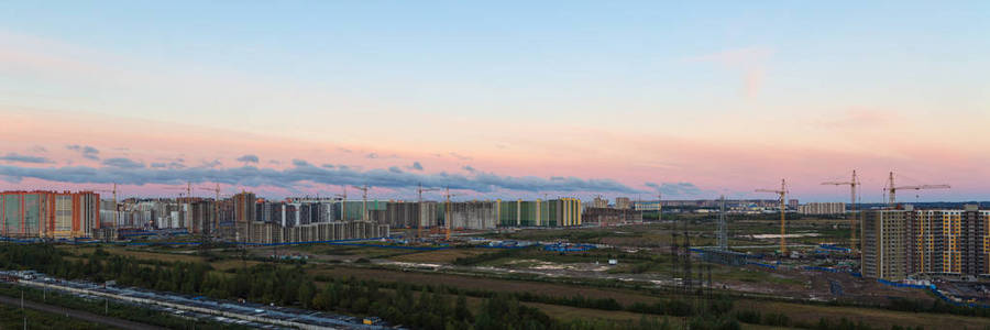 粉红色的天空与云彩在早晨在城市之上和建筑工地