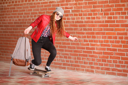 一个年轻的时髦女孩正在骑滑板。女孩女朋友 f