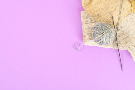 一种羊毛球, 针织针和针织袜子在彩色粉彩桌子上。针线 活