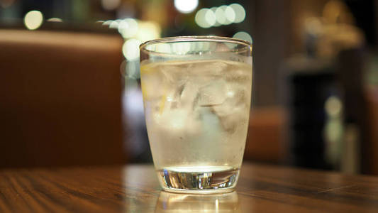 在桌子上的玻璃杯里用冰块清洁水。玻璃中的水, 选择性聚焦