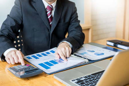 商人在办公桌上办公业务财务分析图表或图表会计计算 bugget 货币税贷款的计算工作