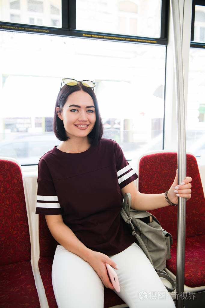 夏天旅行.在时尚的太阳镜下乘坐公交车的快乐微笑的女孩肖像