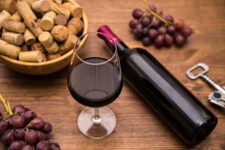 木制背景上的酒瓶葡萄酒杯葡萄和软木酒