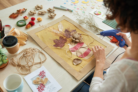 设计师妇女坐在木桌和制作标本室装饰艺术图片