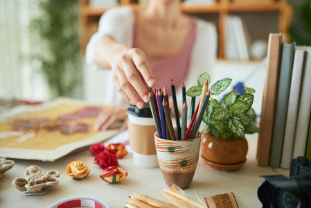 有创意的女人, 坐在木桌上, 拿着彩色铅笔, 做标本室装饰