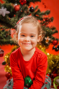 在圣诞树上的小女孩微笑。