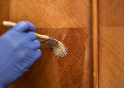 修复部分用画笔除去蜡作为旧家具修复过程的一部分照片