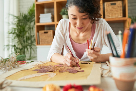 亚洲设计师妇女坐在木桌和制作标本室装饰艺术图片