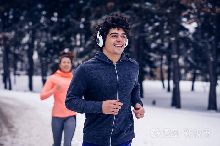 年轻夫妇慢跑在一个冬天的一天