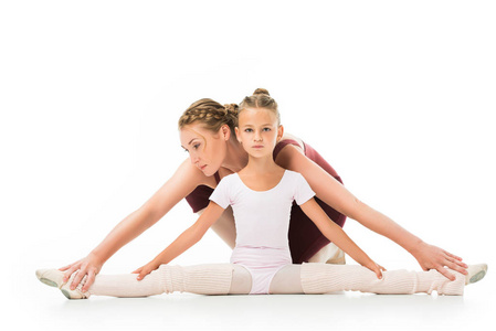 小孩训练成年女性训练师帮助小孩在白色背景下做缠绕照片