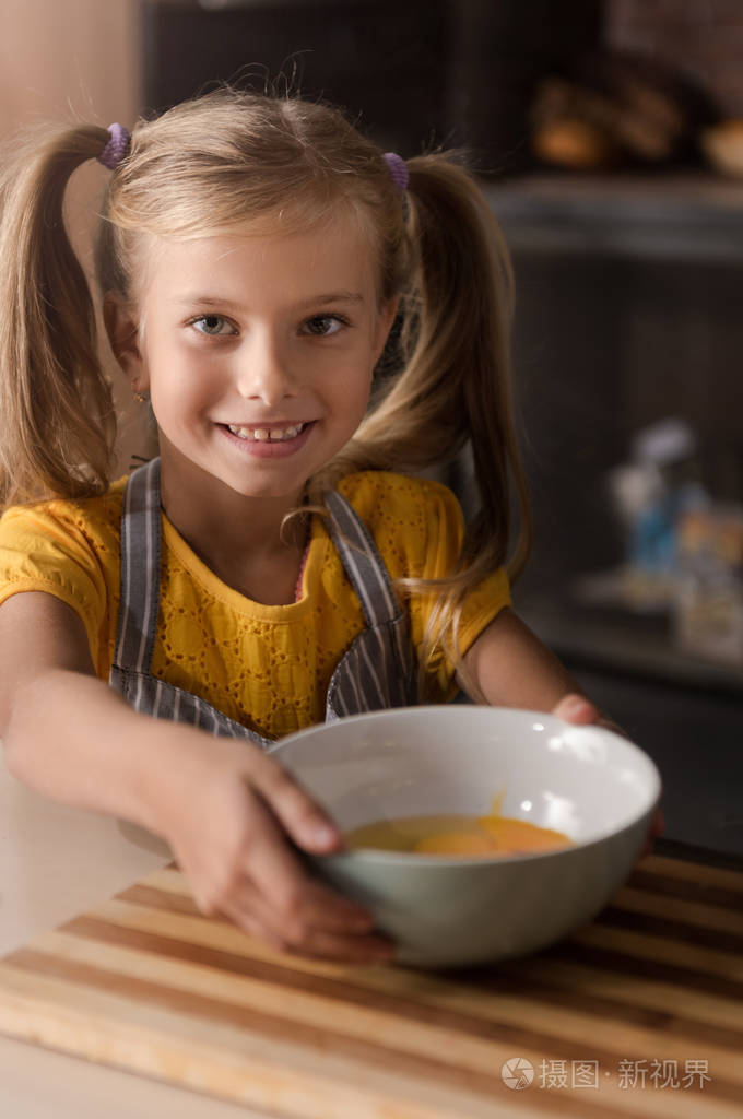 微笑小女孩抱着碗破碎的鸡蛋