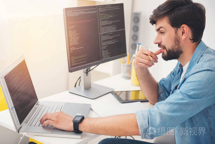 高兴的程序员在笔记本电脑上的工作