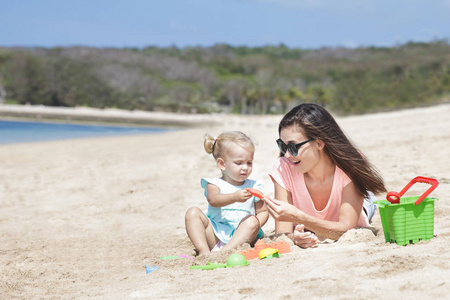 女孩玩沙滩玩具与母亲