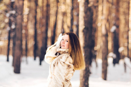 冬天的年轻漂亮的女人，穿着毛皮大衣的画像。雪冬天美容时尚概念