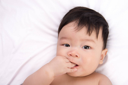 可爱的小亚洲男孩 6 个月大的白色的床上的肖像