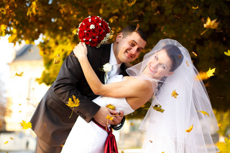 金黄的树叶落在微笑的新婚夫妇