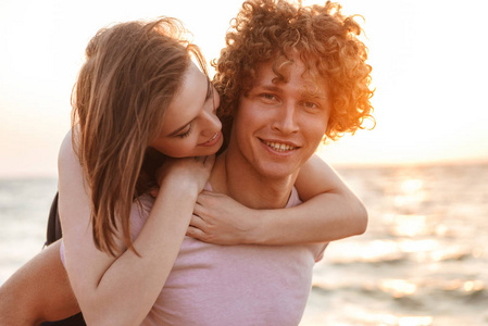 快乐的年轻情侣在海滩上享受户外乐趣的形象