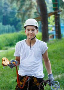 可爱, 运动的男孩在白色 t恤衫和白色头盔在冒险绳索活动公园与头盔和安全设备。年轻的男孩玩, 并有乐趣做户外活动。爱好, 积极的