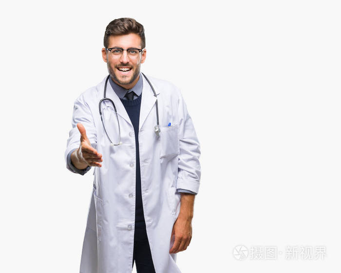 年轻英俊的医生人在孤立的背景微笑友好提供握手作为问候和欢迎。成功的企业