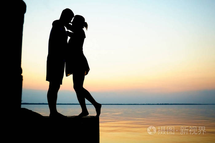 情侣在海滩上相爱.日落海.自然背景
