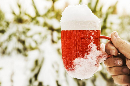 杯子满了雪的男性手