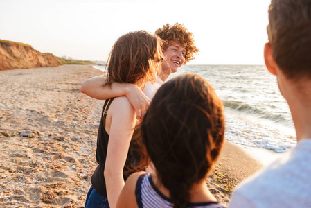 兴奋小组的形象在海滩上散步的朋友爱的夫妇玩得开心