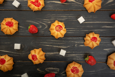 草莓糖和草莓果冻在木质背景下的饼干