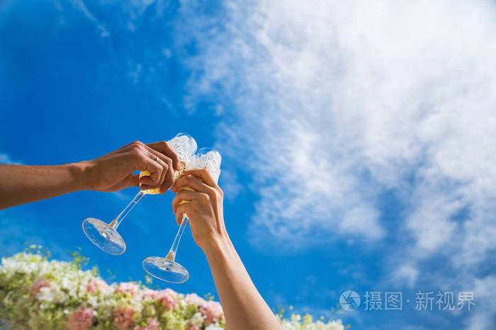 烤面包，香槟玻璃杯提出反对蓝蓝的天空。婚礼那天