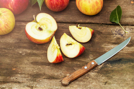 红苹果切片和刀在老木桌上, 色调
