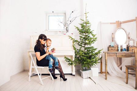 家庭，假期和圣诞节概念   母亲和儿子附近的圣诞树