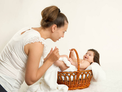 母亲与婴儿在篮子里谈白毛巾，家庭观念，黄色色调