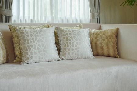 在客厅里的缎面里加米色沙发上设置的图形打印的图案枕头