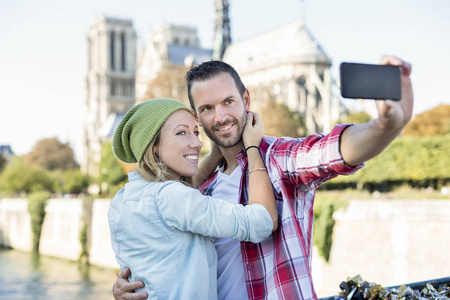年轻夫妇做拍照背景巴黎圣母院大教堂