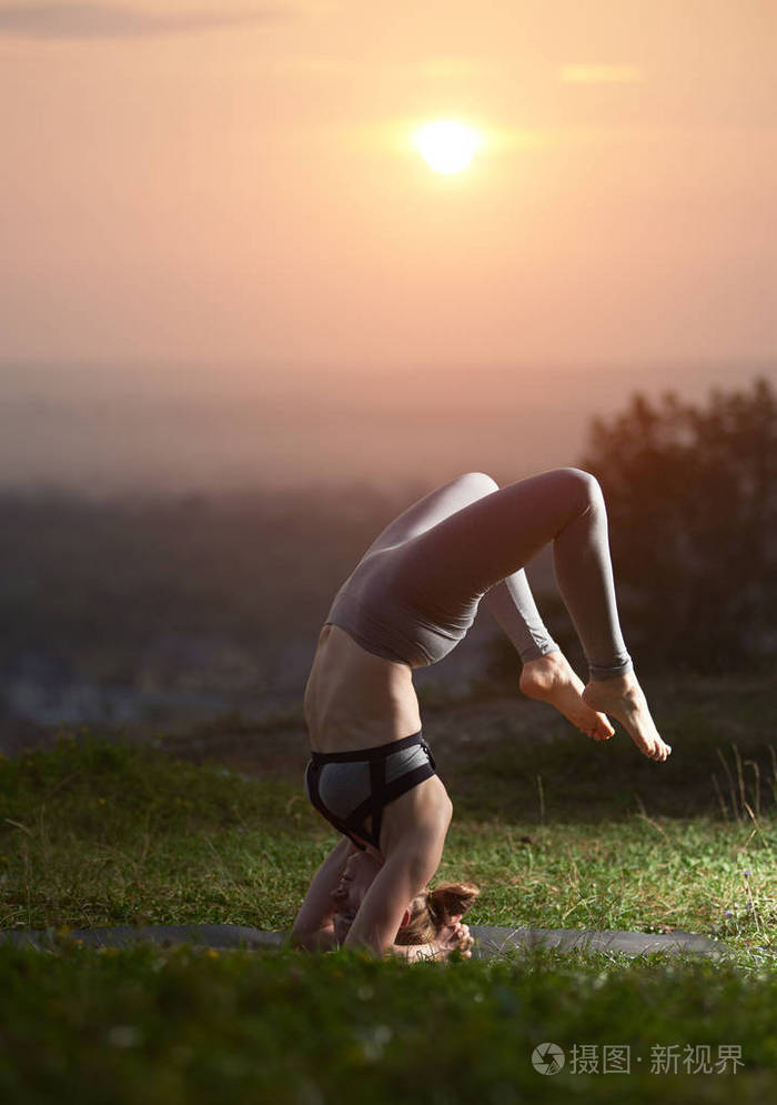 运动的肌肉灵活的女孩在困难平衡瑜伽姿势户外绿色草甸在复制空间背景