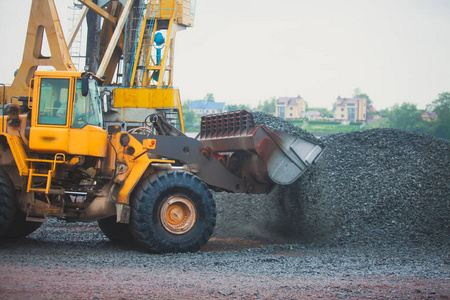 黄色的重型挖掘机和推土机开挖砂和新路施工期间道路工程 卸砂和路金属工作