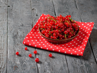 六红醋栗浆果和一碗浆果在一个黑色的木桌上。健康天然食品的概念