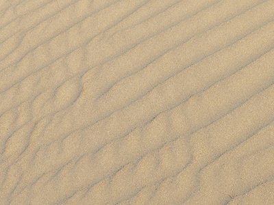 沙滩上或沙漠中的沙粒纹理。沙子的涟漪是对角的