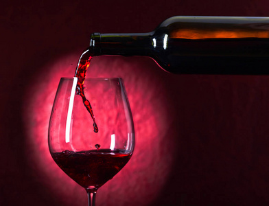瓶子和杯子在深色背景上的红酒图片