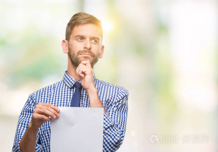 的男人拿着白纸在孤立的背景下严肃的面孔思考问题, 非常困惑的想法