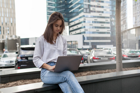 年轻漂亮的自由职业者使用笔记本电脑工作, 而坐在外面, 黑发女商人使用无线连接远程工作在 pc 上的新鲜空气。远程和自由工作的概