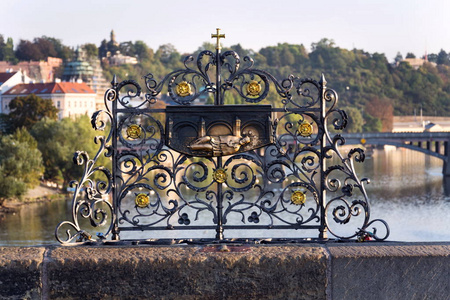 装饰格子与约翰 Nepomuk 青铜雕像在查尔斯桥梁, 布拉格, 捷克共和国, 晴朗的天