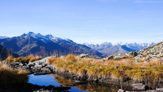 瑞士阿尔卑斯山的野生和风景如画的山区景观在一个美丽的日子在深秋与山和一个伟大的景色和一个小湖的前景