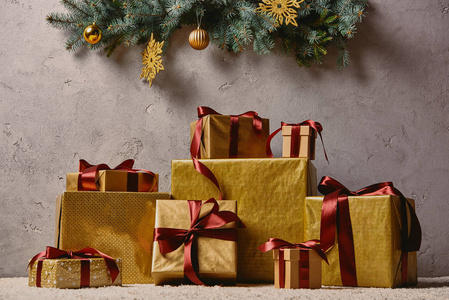 圣诞树下房间地毯上的金色圣诞礼物盒