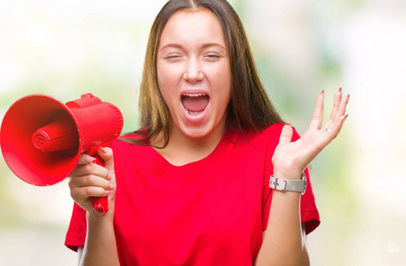 年轻的白种女人尖叫通过扩音器在孤立的背景非常高兴和兴奋, 赢家表达庆祝胜利尖叫与大微笑和举手