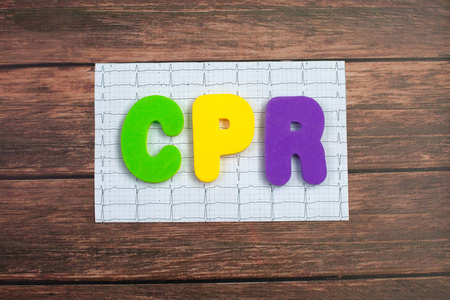 颜色字母表在词 cpr 简称心肺复苏在心脏的打印的心电图在木头背景