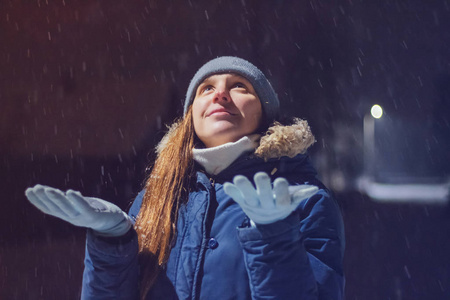 年轻女孩在冬天捕捉雪花图片