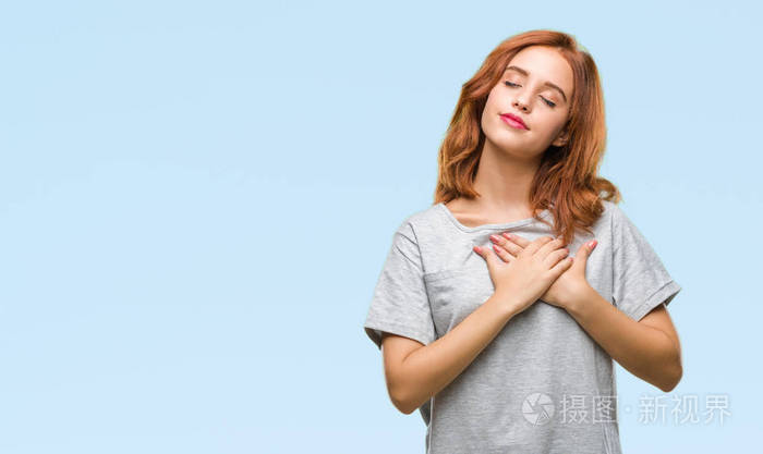 年轻美丽的女人在孤独的背景微笑着双手在胸前闭上眼睛和感激的手势